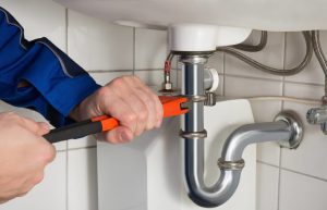 photo-of-a-plumber-tightening-pipe Photo of a plumber tightening drainage pipe