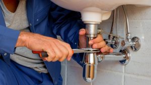 picture-of-a-plumber-fixing-drain Plumber fixing drain photo