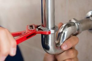 photo-of-a-plumber-fixing-pipe-with-a-wrench same day plumbing denver