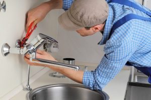 Plumber Fixing Faucet