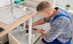 picture if a plumber nearby repairing sin drainage