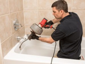 plumber photo using drain snake