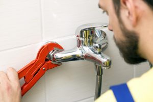 licensed-plumber-installing-faucet-photo licensed plumber installing faucet photo