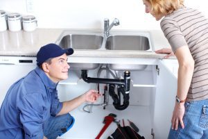 picture of a professional plumber showing the plumbing problem to customer