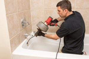 professional-plumber-cleaning-bathtub-photo Emergency Plumber in Modesto, California
